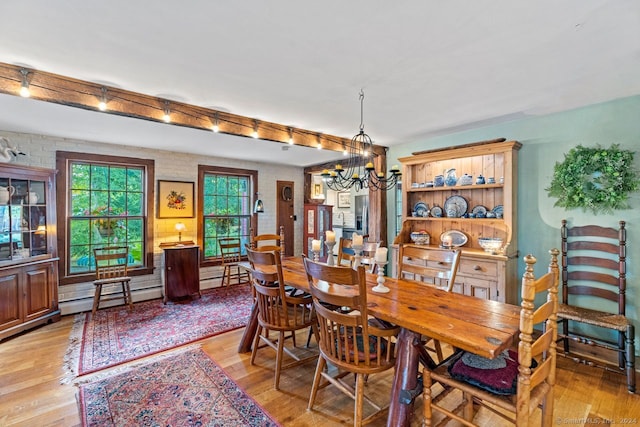 dining area featuring an inviting chandelier, light hardwood / wood-style flooring, and a baseboard radiator