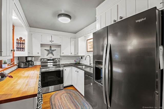 kitchen with appliances with stainless steel finishes, white cabinetry, sink, and tasteful backsplash