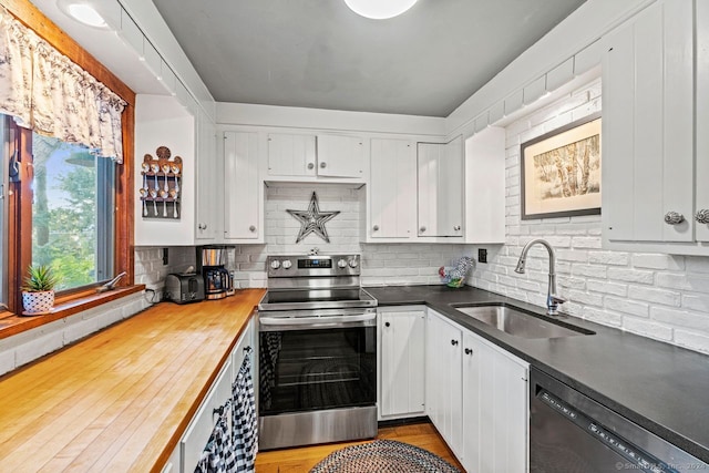 kitchen featuring dishwashing machine, stainless steel electric stove, sink, and white cabinetry