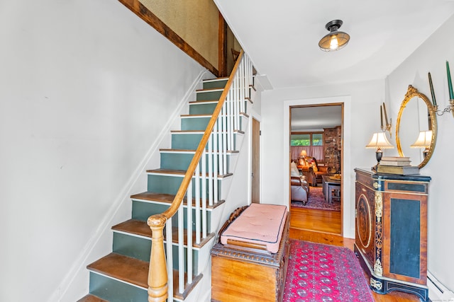 stairs with a baseboard radiator and hardwood / wood-style flooring