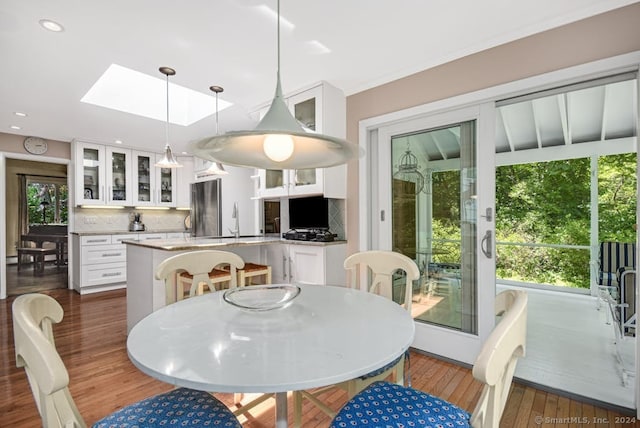 dining space featuring dark wood-type flooring, a skylight, and sink