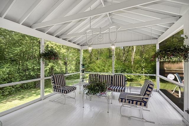 sunroom / solarium featuring lofted ceiling with beams