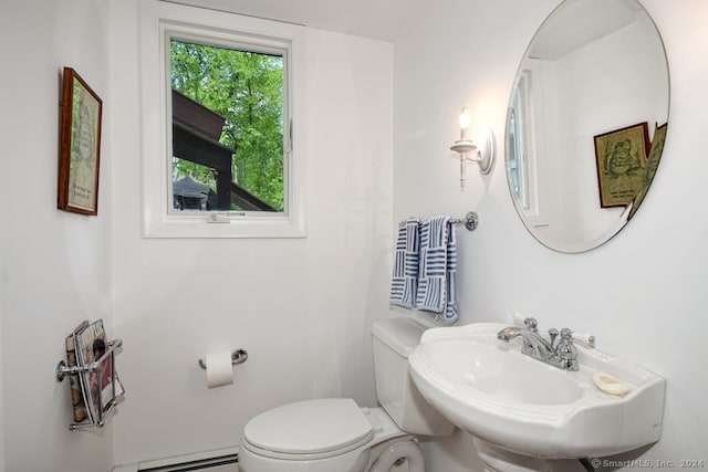 bathroom featuring sink, toilet, and baseboard heating