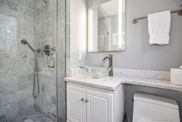 bathroom with a shower with door, vanity, and toilet