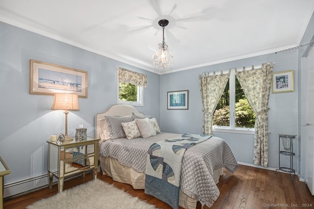 bedroom featuring baseboard heating, ornamental molding, dark hardwood / wood-style floors, and a chandelier