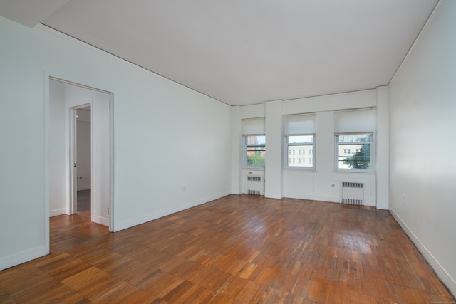 empty room featuring radiator and dark hardwood / wood-style flooring