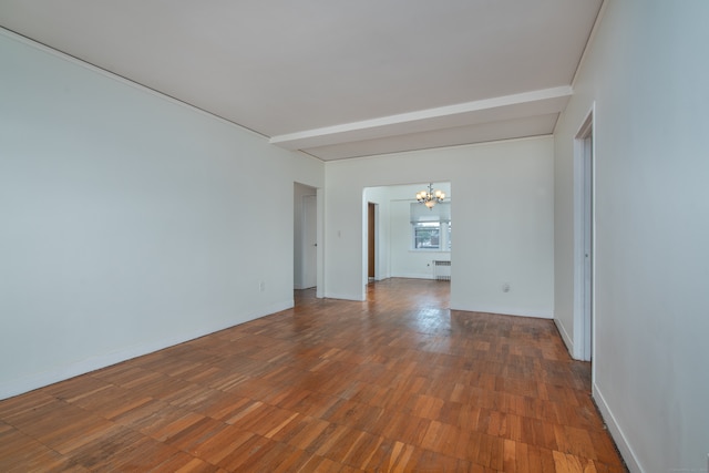 spare room with hardwood / wood-style flooring, radiator, and a notable chandelier