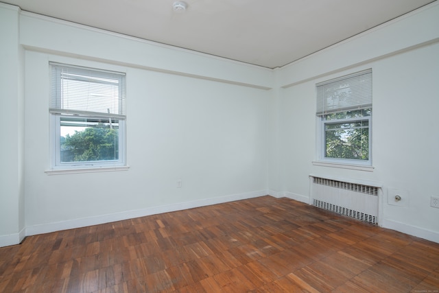 spare room featuring dark hardwood / wood-style floors and radiator heating unit