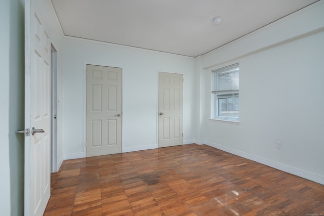 unfurnished bedroom with dark hardwood / wood-style flooring