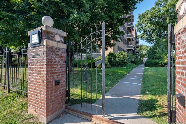 view of gate with a yard