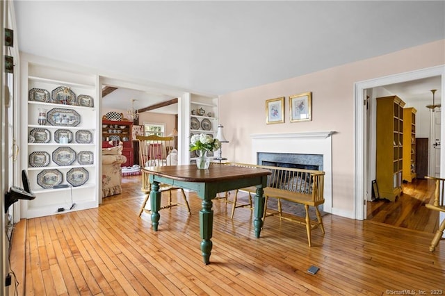 dining space with hardwood / wood-style flooring and built in shelves