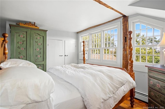 bedroom with hardwood / wood-style flooring and baseboard heating