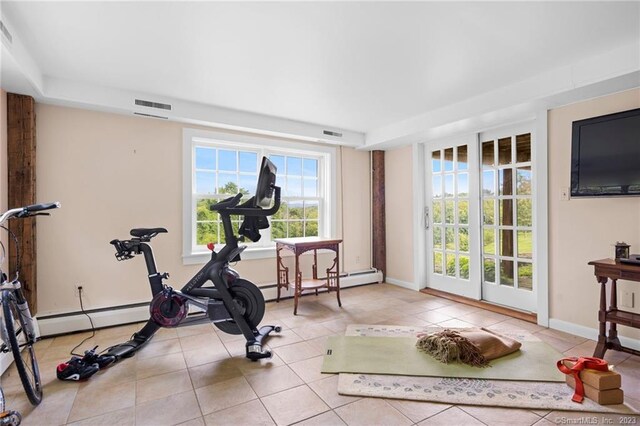 workout area with a baseboard heating unit and light tile patterned floors