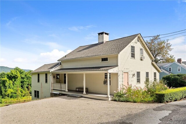 rear view of property with covered porch