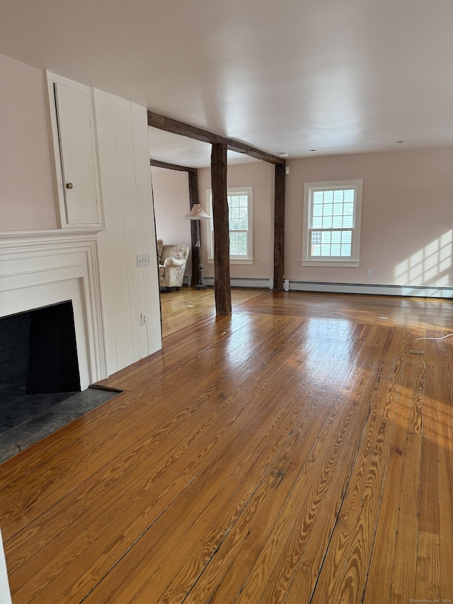 unfurnished living room featuring wood-type flooring and baseboard heating