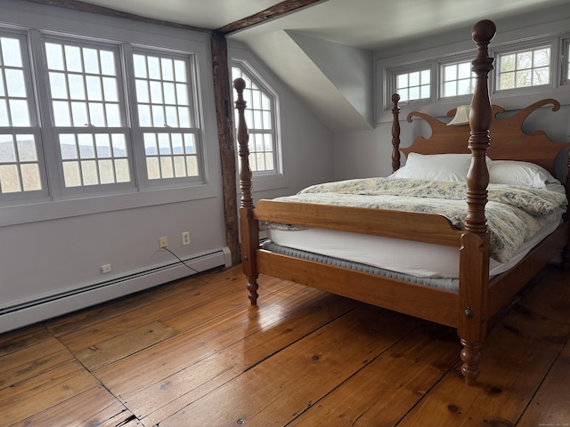 bedroom featuring multiple windows, hardwood / wood-style floors, and baseboard heating