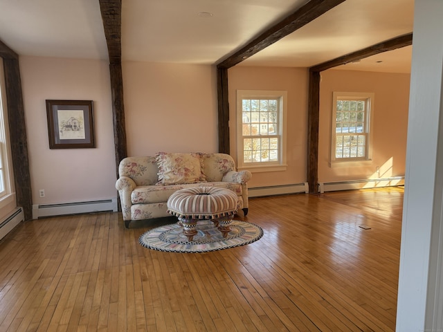 living area featuring light hardwood / wood-style flooring, beam ceiling, and a baseboard radiator