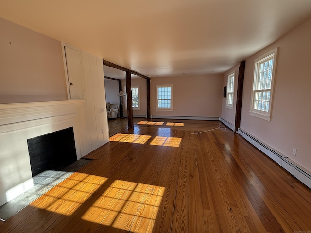 unfurnished living room with hardwood / wood-style flooring and baseboard heating