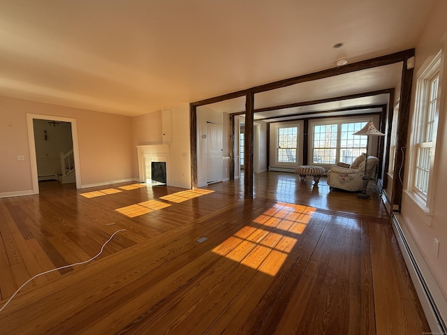 unfurnished living room featuring dark hardwood / wood-style floors and baseboard heating