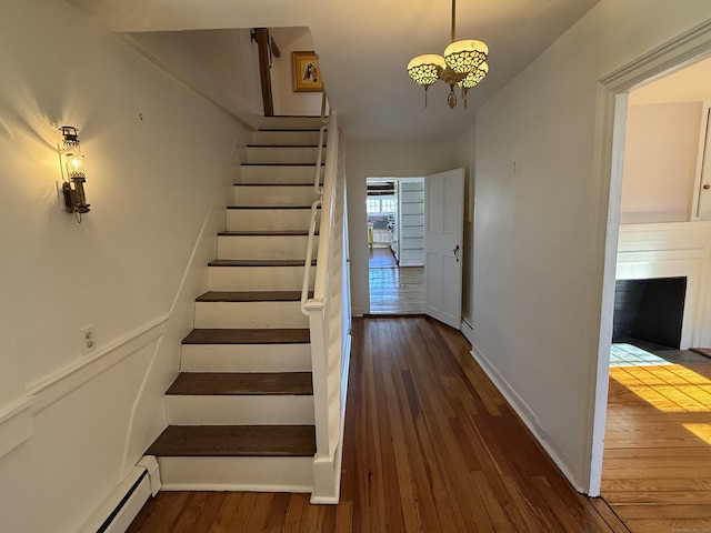 stairs featuring a baseboard radiator and hardwood / wood-style floors