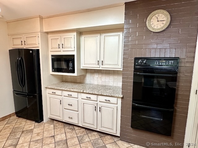 kitchen featuring decorative backsplash, white cabinets, black appliances, and light stone counters