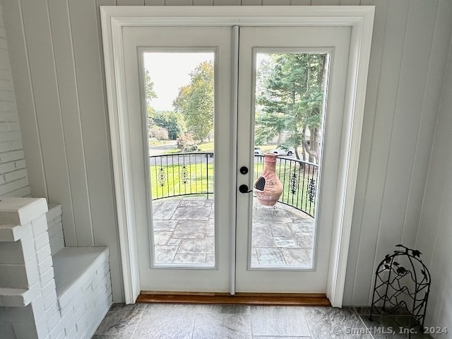 doorway to outside featuring wooden walls