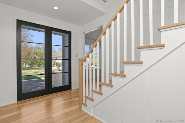 entrance foyer with french doors and light hardwood / wood-style floors