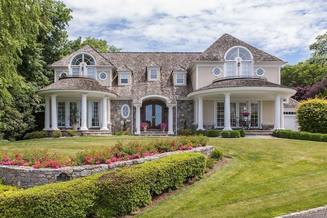 view of front of house with covered porch, a front lawn, and french doors