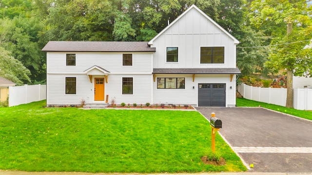 modern farmhouse featuring a garage and a front lawn