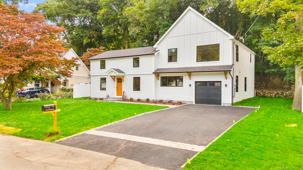 modern farmhouse style home featuring a garage and a front yard