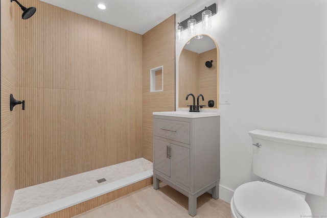 bathroom featuring tile patterned flooring, vanity, toilet, and a shower