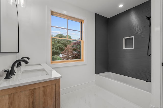 bathroom featuring a bathing tub, vanity, and a healthy amount of sunlight