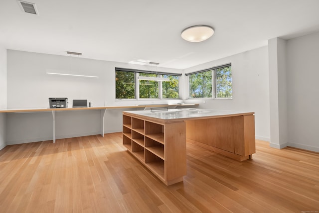 kitchen with decorative light fixtures, light hardwood / wood-style flooring, and a center island