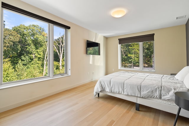 bedroom featuring light hardwood / wood-style flooring and multiple windows