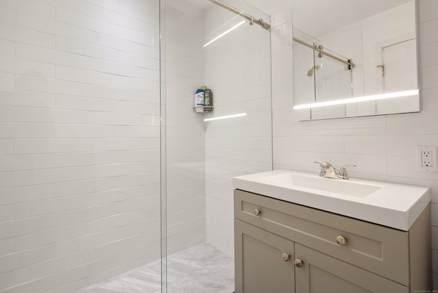 bathroom featuring vanity, tile walls, and a tile shower