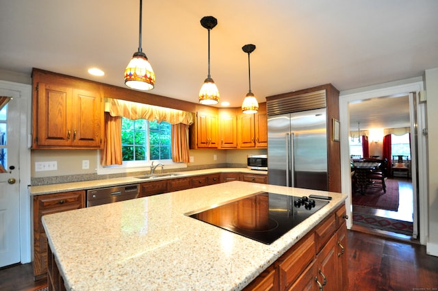 kitchen with pendant lighting, sink, stainless steel appliances, dark hardwood / wood-style flooring, and light stone countertops