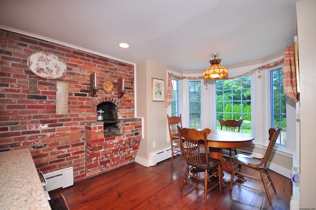 dining room featuring brick wall, plenty of natural light, dark hardwood / wood-style flooring, and a baseboard radiator