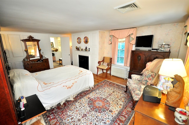 bedroom with wood-type flooring and radiator