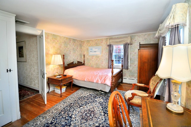 bedroom featuring wood-type flooring, ornamental molding, and a baseboard radiator