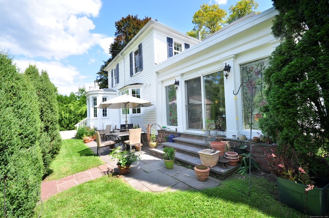 back of house featuring a patio and a lawn