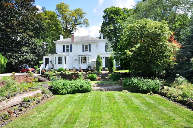 rear view of house featuring a yard