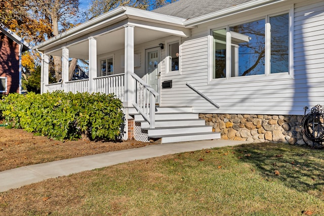 property entrance featuring a lawn and a porch