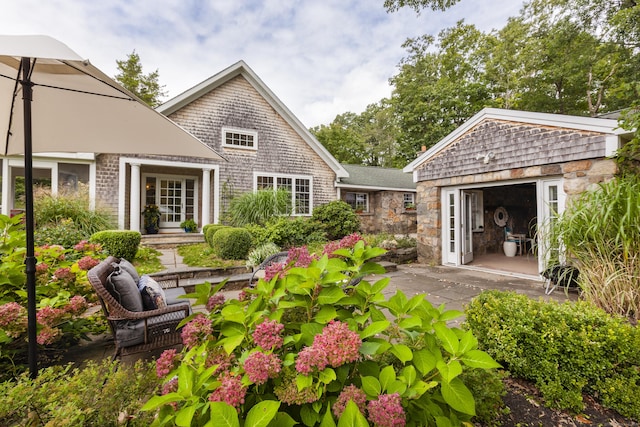 rear view of property with a patio area and an outdoor structure