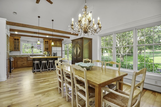 dining space featuring beamed ceiling, a baseboard heating unit, a towering ceiling, light hardwood / wood-style floors, and ceiling fan with notable chandelier