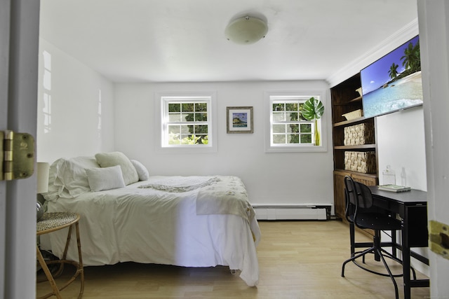 bedroom with light hardwood / wood-style flooring and a baseboard radiator