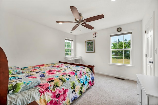 bedroom featuring ceiling fan, carpet flooring, and multiple windows