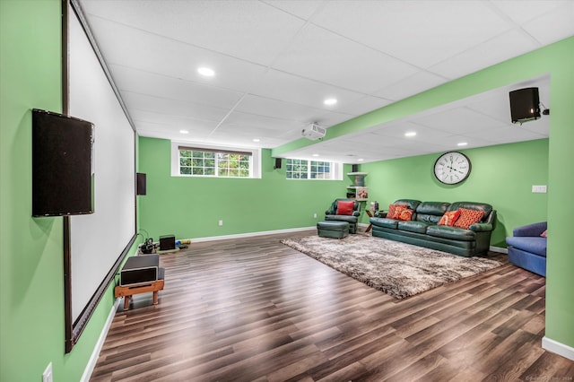 living room featuring a drop ceiling and dark wood-type flooring