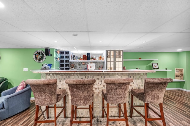 bar featuring a paneled ceiling and wood-type flooring