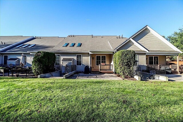 back of house with a wooden deck, a yard, and a patio