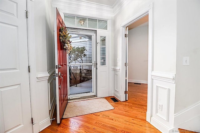 entrance foyer featuring light hardwood / wood-style floors and crown molding